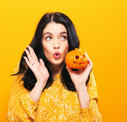 Young woman holding a pumpkin in halloween theme