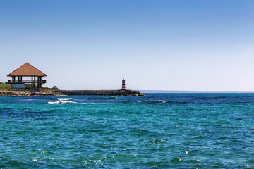 Bungalow and a lighthouse on the seashore