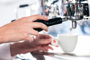 Fototapeta na wymiar Close-up of female hand on the portafilter of an automatic coffee machine
