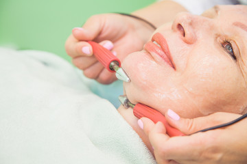 muscle toning procedure for senior woman in cosmetology clinic