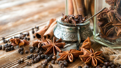 Aromatic spices on a rustic background. Clove, cinnamon in sticks, anise illicium, black...