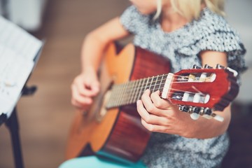 Girl learning to play to the guitar - obrazy, fototapety, plakaty