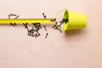 Roulette measuring pulling a bucket of nails. Still life.