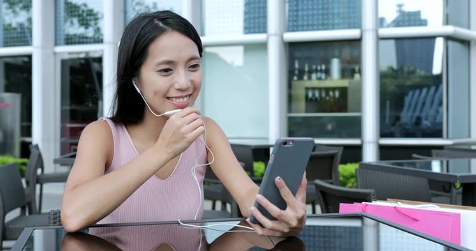Woman talking to cellphone in outdoor cafe