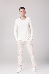 Fototapeta premium handsome young man in a white sweater and pants 