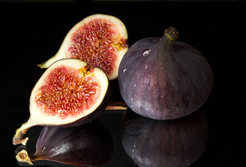 Figs, half of figs on black background. Dieting healthy eating concept.