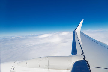 A view from the airplane window to the wing and clouds.