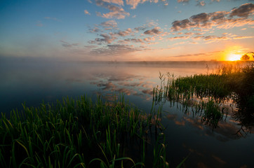 beautiful sunrise over misty lake