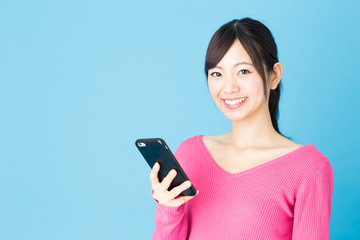 Fototapeta premium portrait of young asian woman isolated on blue background