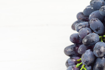 Bunch of fresh ripe blue grapes on old wooden rustic white planks