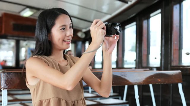 Woman taking photo with digital camera on ferry