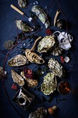 Seafood feast with oysters and wine, arranged on dark blue