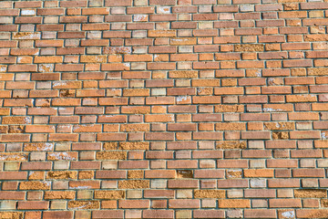 Background wall is red ancient bricks, orange textured fence. Architectural walls are handmade.
