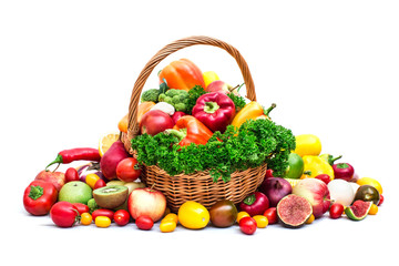 Composition with vegetables and fruits in wicker basket isolated on white.