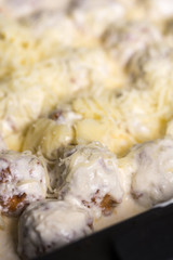 Meatballs with yogurt sauce and cheese ready for baking