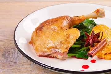 Duck leg with spinach, orange and spices: cinnamon and star anise in red wine sauce, horizontal