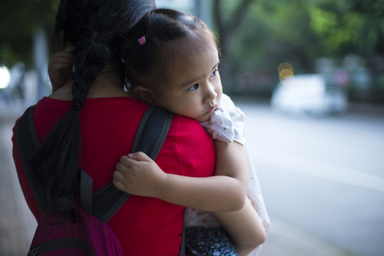 lovely little asian girl on her mother's shouder
