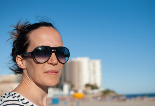 woman on the beach with big sunglasses