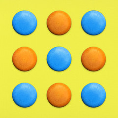 Macaroons Top view Nine orange and blue sweet macaroons or macaron on yellow background French dessert Trendy bright photo in pop art style