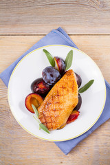 Duck breast with plums and sage. View from above, top studio shot, vertical