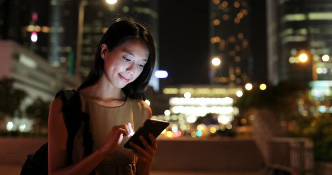 Young Woman using mobile phone in city at night