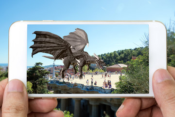 Augmented reality marketing technology concept. Customer hand holding smart phone use AR application to see 3d rendering dragon popup of screen phone in city background. - obrazy, fototapety, plakaty