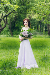 Obraz na płótnie Canvas Woman in long white dress in summer garden