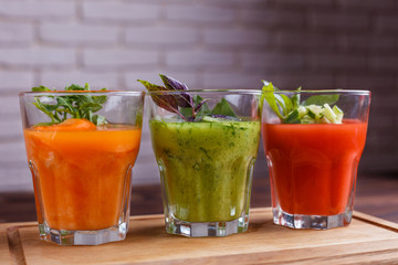 Diet concept, healthy lifestyle, low calorie detox and dietary food. Set of vegetable smoothie in glasses on wooden table