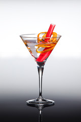 Vodka cocktail with dry vermouth and orange bitter. Decorated with orange peel and rhubarb. In martini glass.