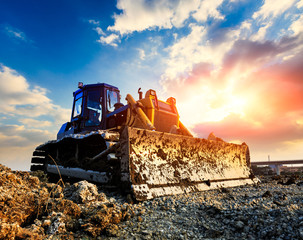bulldozer on a building site at sunset