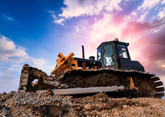 bulldozer on a building site at sunset