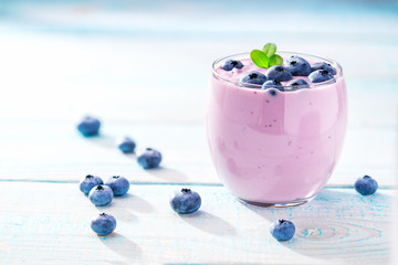 Blueberry smoothie in a glass on a rustic table