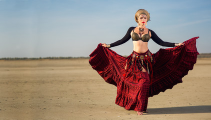 The girl in red long dress of american tribal style.