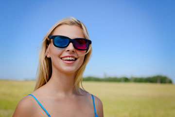 Beautiful girl watching movie with 3d glasses and eating popcorn. She is very expressive