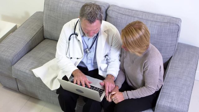 Doctor shows female patient laptop
