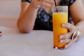 Glass of refreshing cool mango lassi sweet Indian drink over restaurant table light background