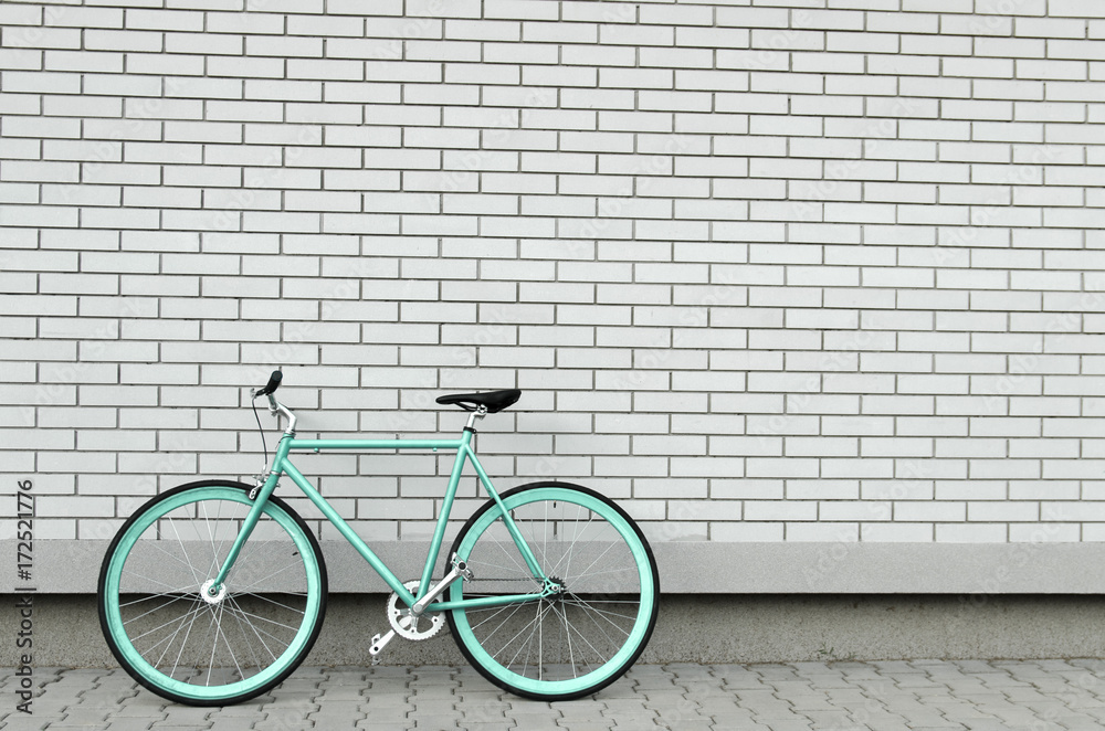 Wall mural Teal bicycle next to white brick wall, copy space, no people 