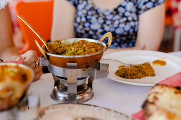 Closeup on Indian speciality curry dish over light restaurant table background. Traditional maincourse delicacy