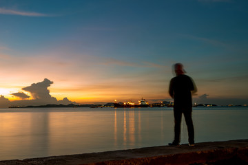 fishing man and beautiful sunset skies at coastal port