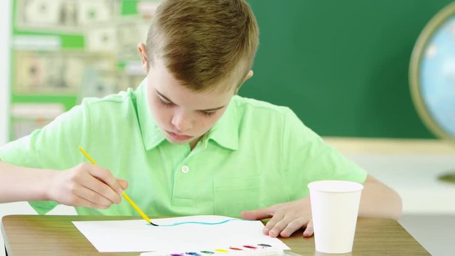 Young boy using water paints