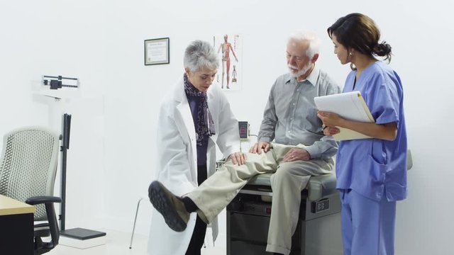 Doctor and nurse talking to elderly patient
