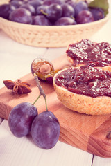 Vintage photo, Fresh prepared sandwiches with plum marmalade or jam on wooden cutting board, breakfast concept