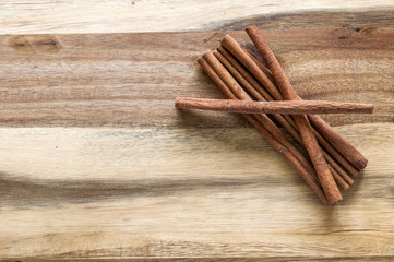Cinnamon stick pile on a wooden background 
