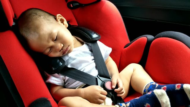 Asian boy about 1 year and sixth months sleeping in baby car seat