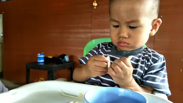 Asian boy about 1 year and sixth months eating and play with bean sprout