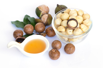 Closeup view of natural macadamia oil and Macadamia nuts on wooden board. Healthy food