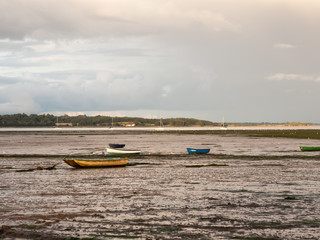 estuary scene in manningtree with moored boats tide clouds landscape