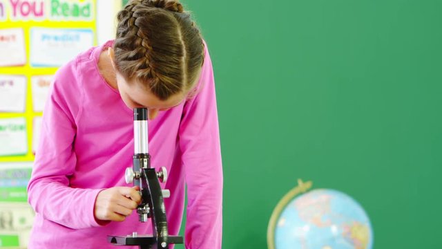 young girl using microscope