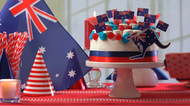 4k Australian celebration party table with showstopper cake decorated with candy, stars and flags, placing cake on the table.