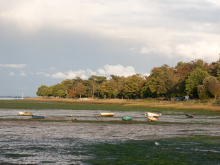 estuary scene in manningtree with moored boats tide clouds landscape
